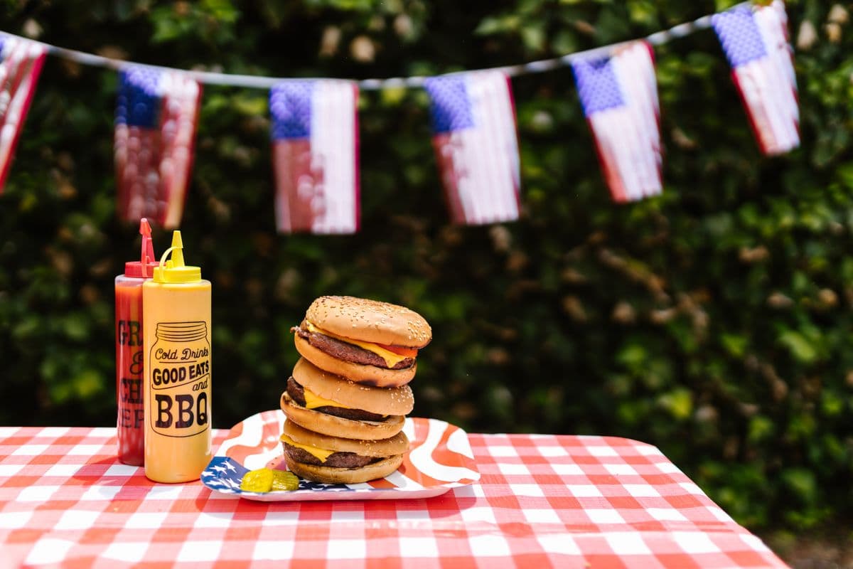 Burgers on a picnic table with American flag bunting