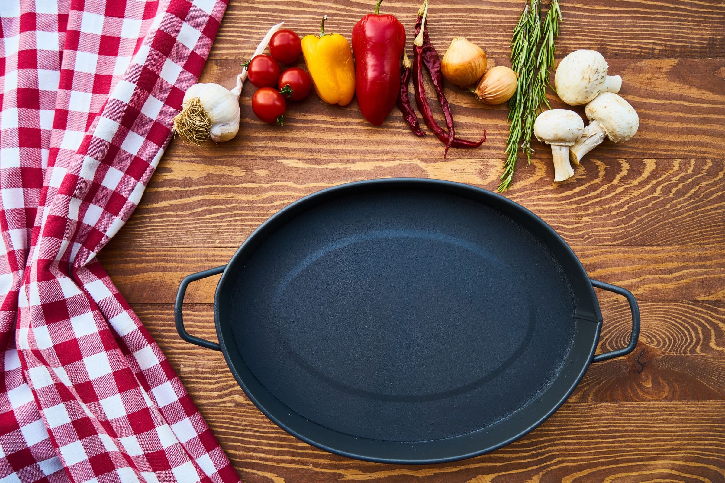 Cast iron pan with fresh ingredients on a wooden table
